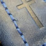 Blue leather bookmark being used in a Bible