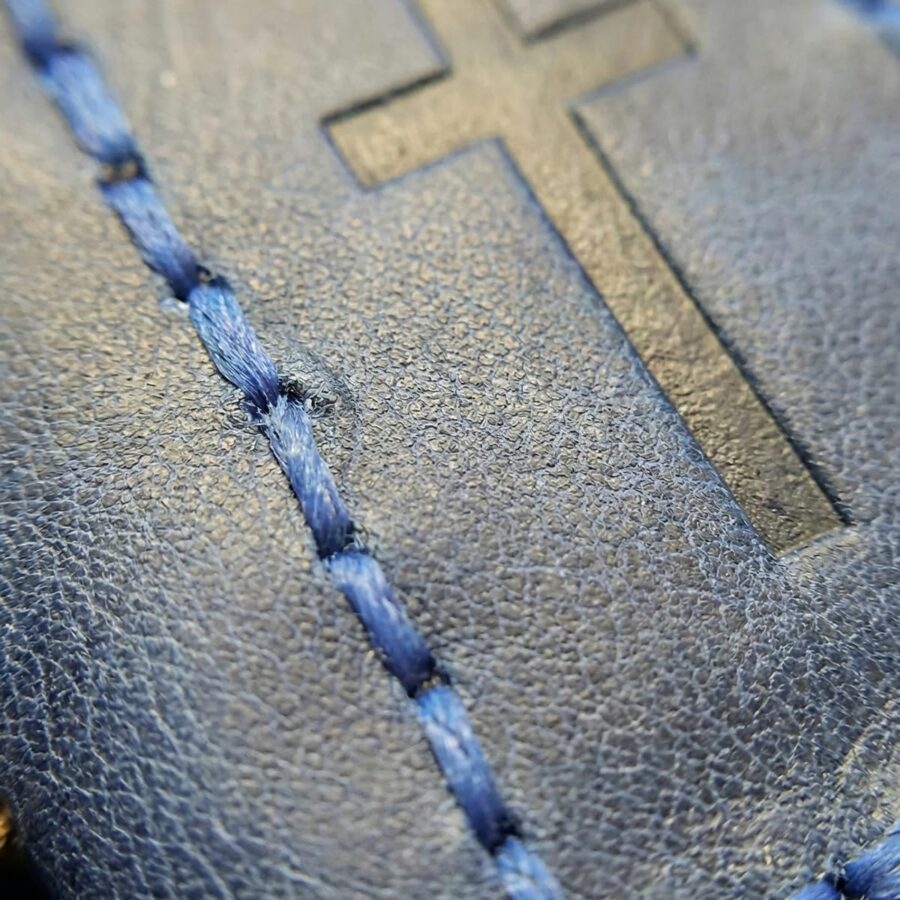 Blue leather bookmark being used in a Bible