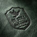 CGU-BKM-GREEN full-grain leather texture and debossed verse close-up