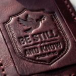 CGU-LUG-RED full-grain leather texture and debossed verse close-up