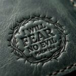 CGU-SCR-GREEN full-grain leather texture and debossed verse close-up